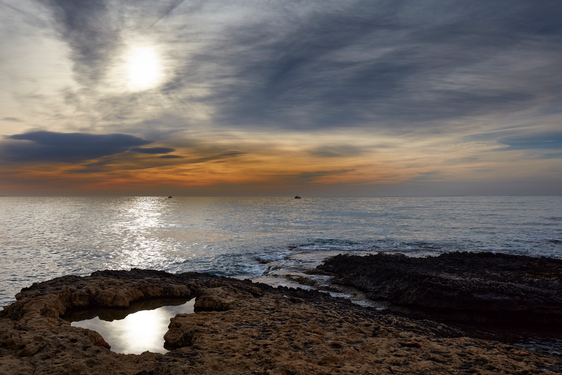 Puesta de sol sobre el mar desde las rocas