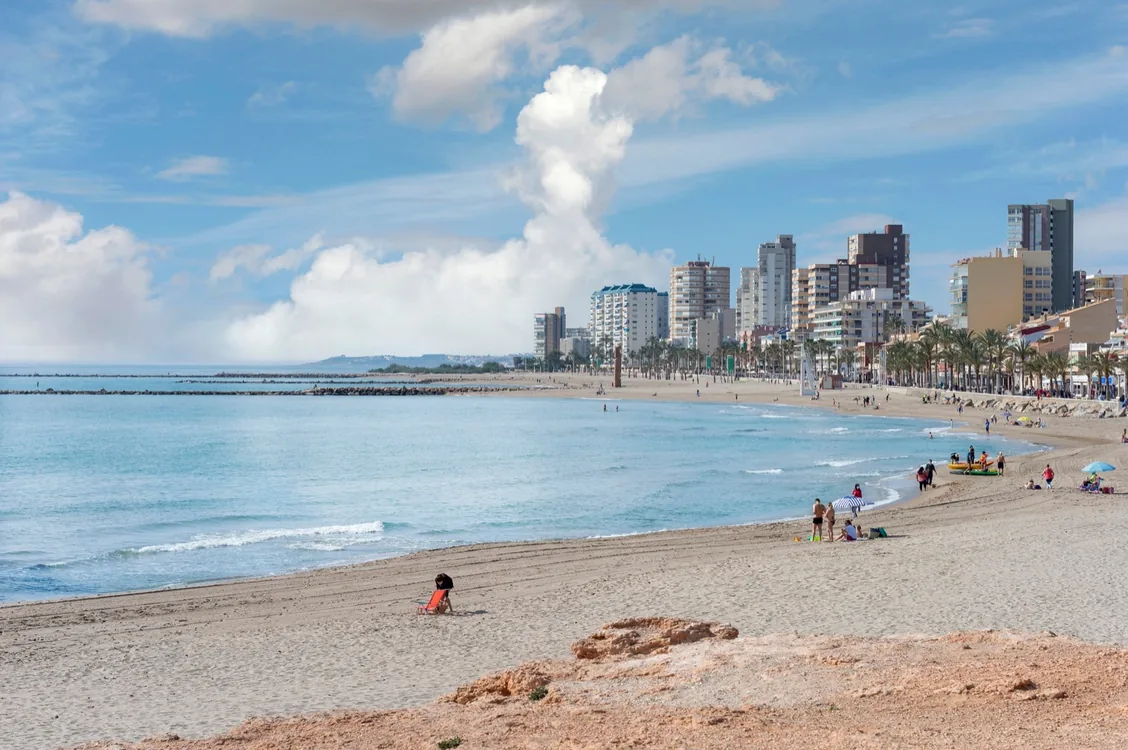 Playa de arena de El Campello con el pueblo al fondo